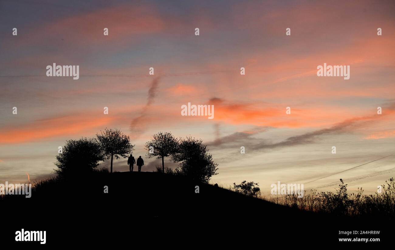 Hannover, Deutschland. 15 Okt, 2019. Ein Paar geht für einen Spaziergang bei Sonnenaufgang auf dem Kronsberg. Credit: Julian Stratenschulte/dpa/Alamy leben Nachrichten Stockfoto