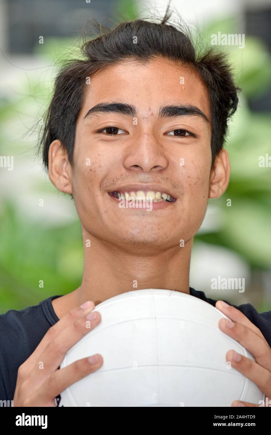 Minderheit männlichen Athleten lächelnd mit Volleyball Stockfoto