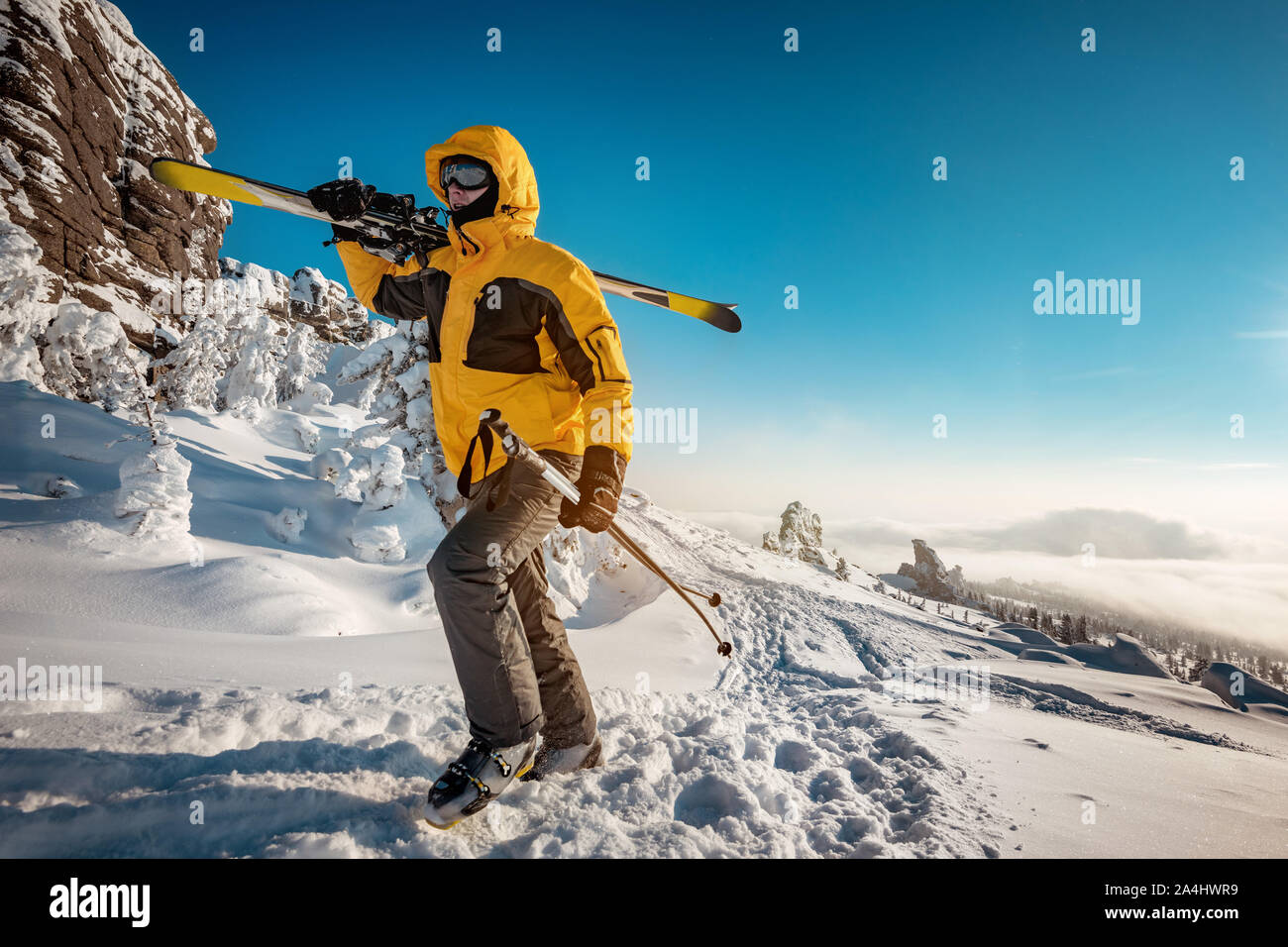Skifahrer mit Ski in der Hand geht bergauf für Skitouren. Ski Resort Konzept Stockfoto