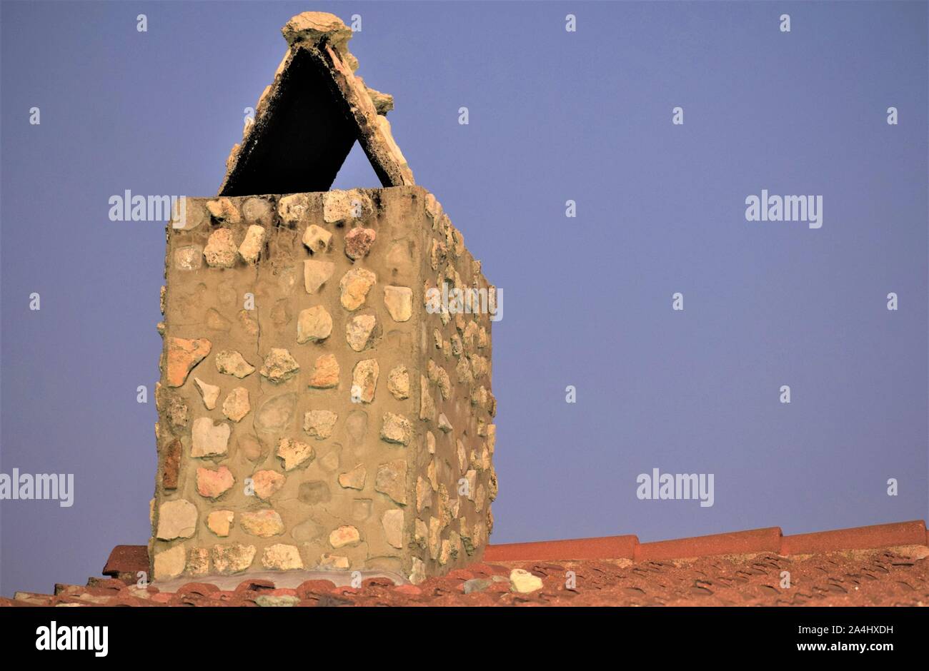Stein Schornstein auf dem Dach mit Terracotta Fliesen Stockfoto