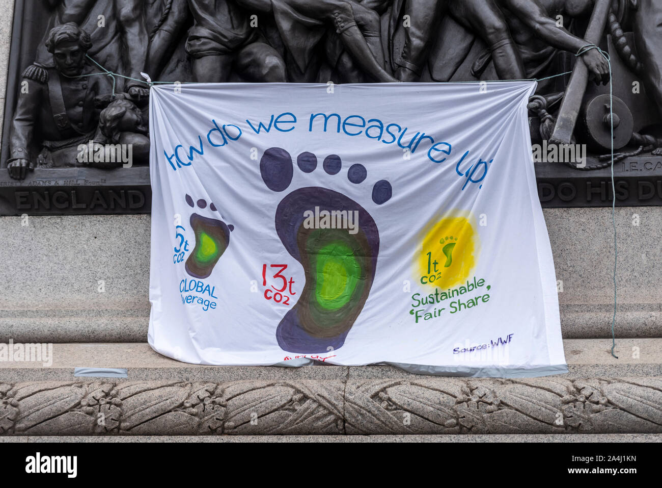 Aussterben Rebellion Morgendunst am Trafalgar Square, London, UK. Protest Camp. Banner auf Bronze Fries der Nelson's Column. Co2-Fußabdruck Stockfoto