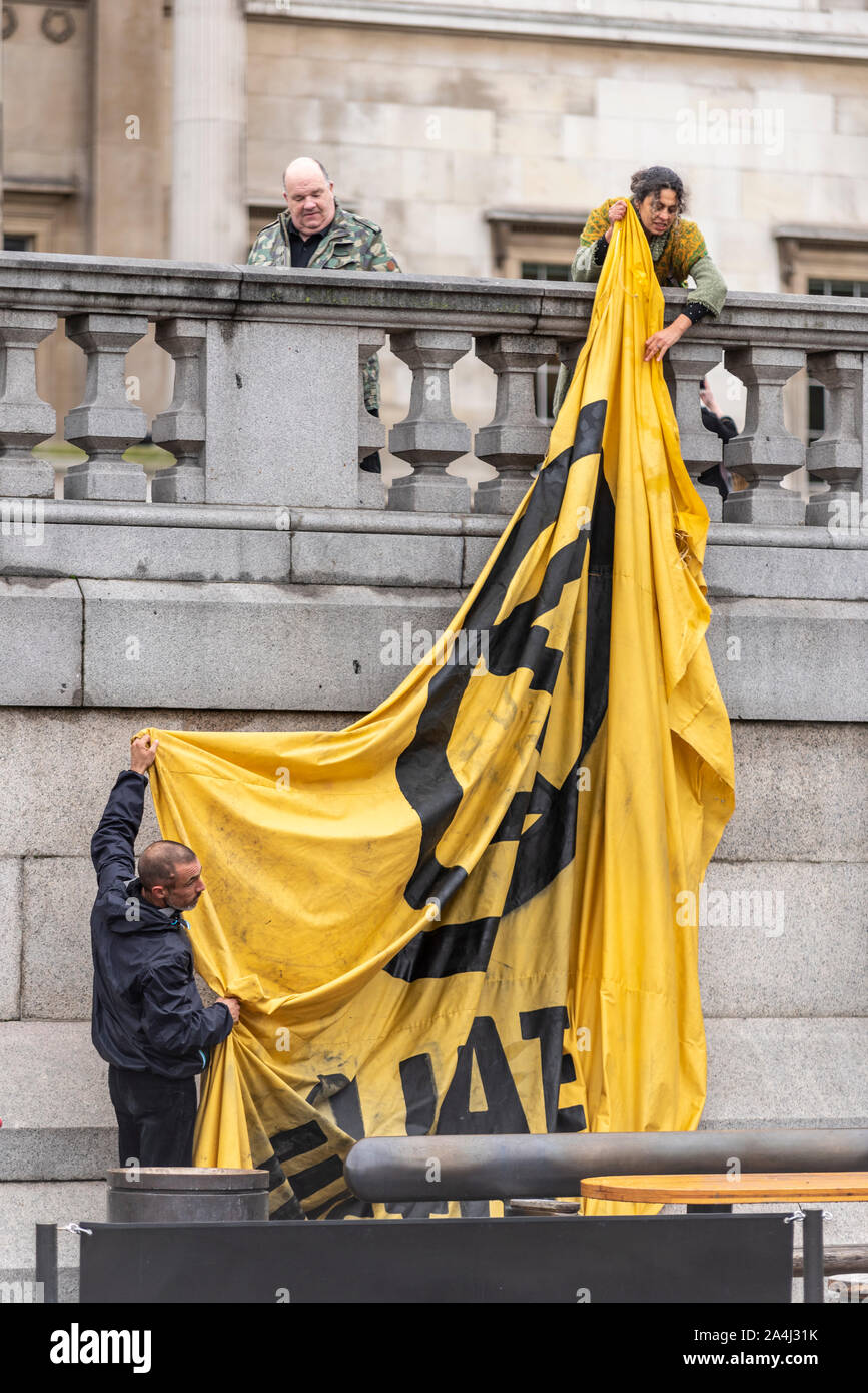 Aussterben Rebellion Morgendunst am Trafalgar Square, London, UK. Protest Camp. Aktivisten, die gerade ein großes Banner Stockfoto