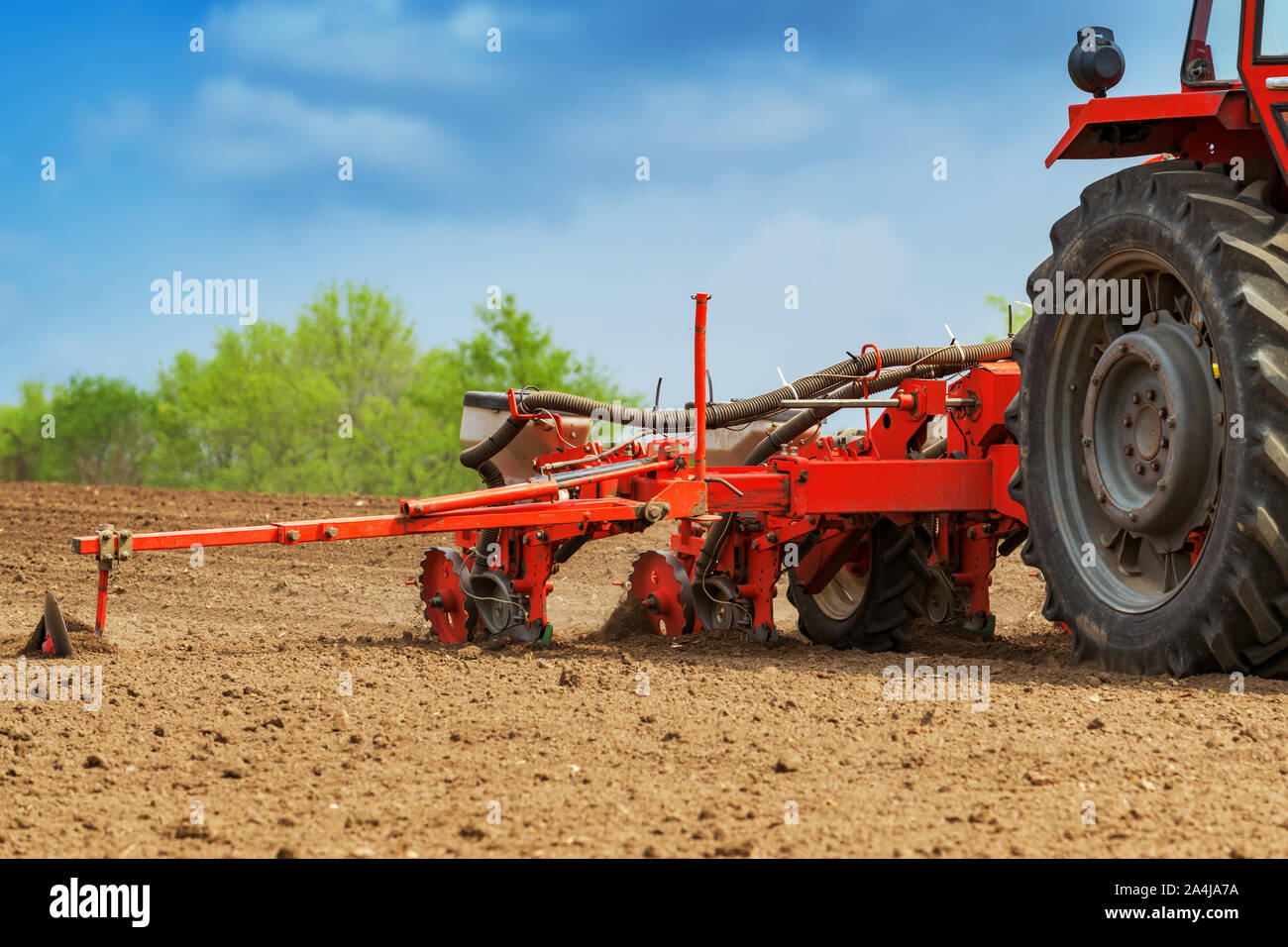 Traktor mit angebautem Getreide Sämaschine Aussaat Mais Saatgut im Feld Stockfoto