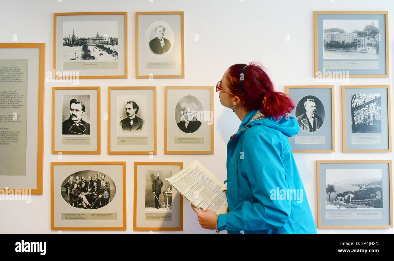 Naumburg, Deutschland. 03 Okt, 2019. In der Nietzsche Haus eine Frau sieht auf Fotos der Philosoph Friedrich Nietzsche und seinem Aufenthalt in Basel (Schweiz). Der Philosoph Friedrich Nietzsche mit seiner Mutter und seiner Schwester in Naumburg von 1858 bis 1897 lebte. Er wurde am 15.10.1844 in Röcken in der Nähe von Leipzig geboren und starb 1900 in Weimar. Anlässlich seines 175-jährigen Geburtstag, dem 30. Internationalen Nietzsche Kongress findet in der naumburger Nietzsche Documentation Center vom 17. bis 20. Oktober 2019. Credit: Waltraud Grubitzsch/dpa-Zentralbild/ZB/dpa/Alamy leben Nachrichten Stockfoto