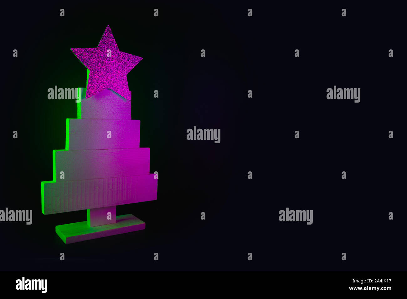 Weihnachtsbaum in Neon Pink und Grün auf Schwarz. Kreative Muster mit Platz für Text und Urlaubswünsche. Xmas Party Hintergrund. Stockfoto