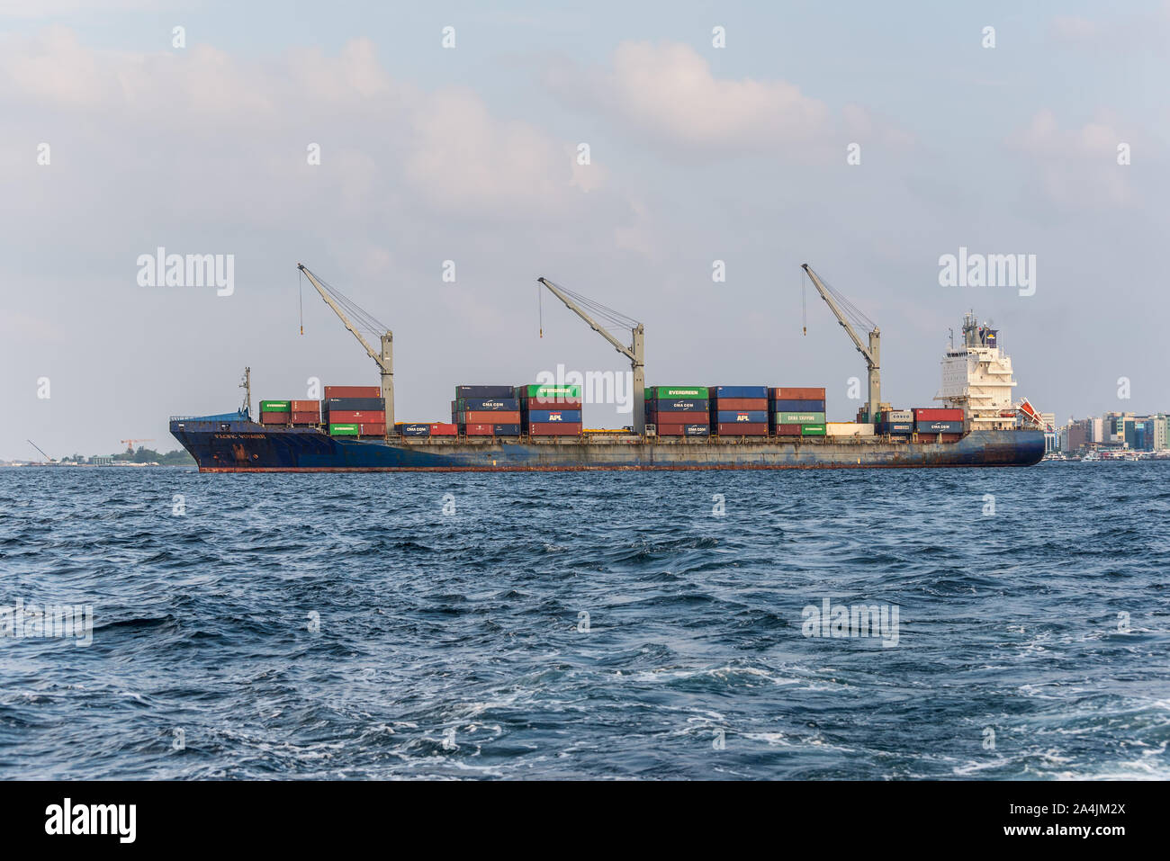 Male, Malediven - November 17, 2017: Container schiff PACIFIC VOYAGER Im äußeren Hafen der männlichen Insel vom Boot auf den Malediven, Indischer Ozean gesehen. Stockfoto