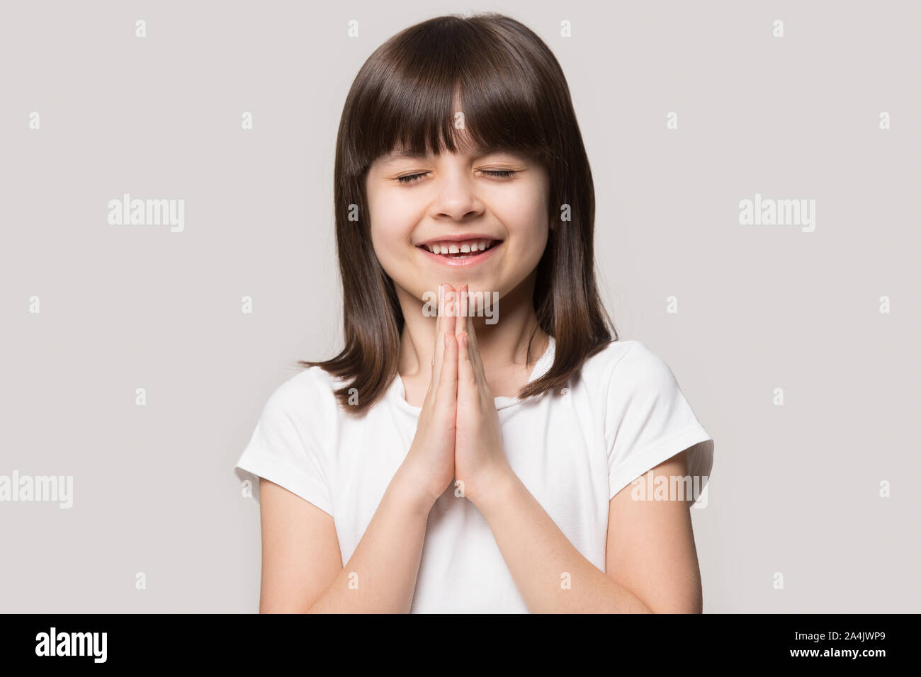 Süße kleine Mädchen halten Hände im Gebet beten zu Gott Stockfoto