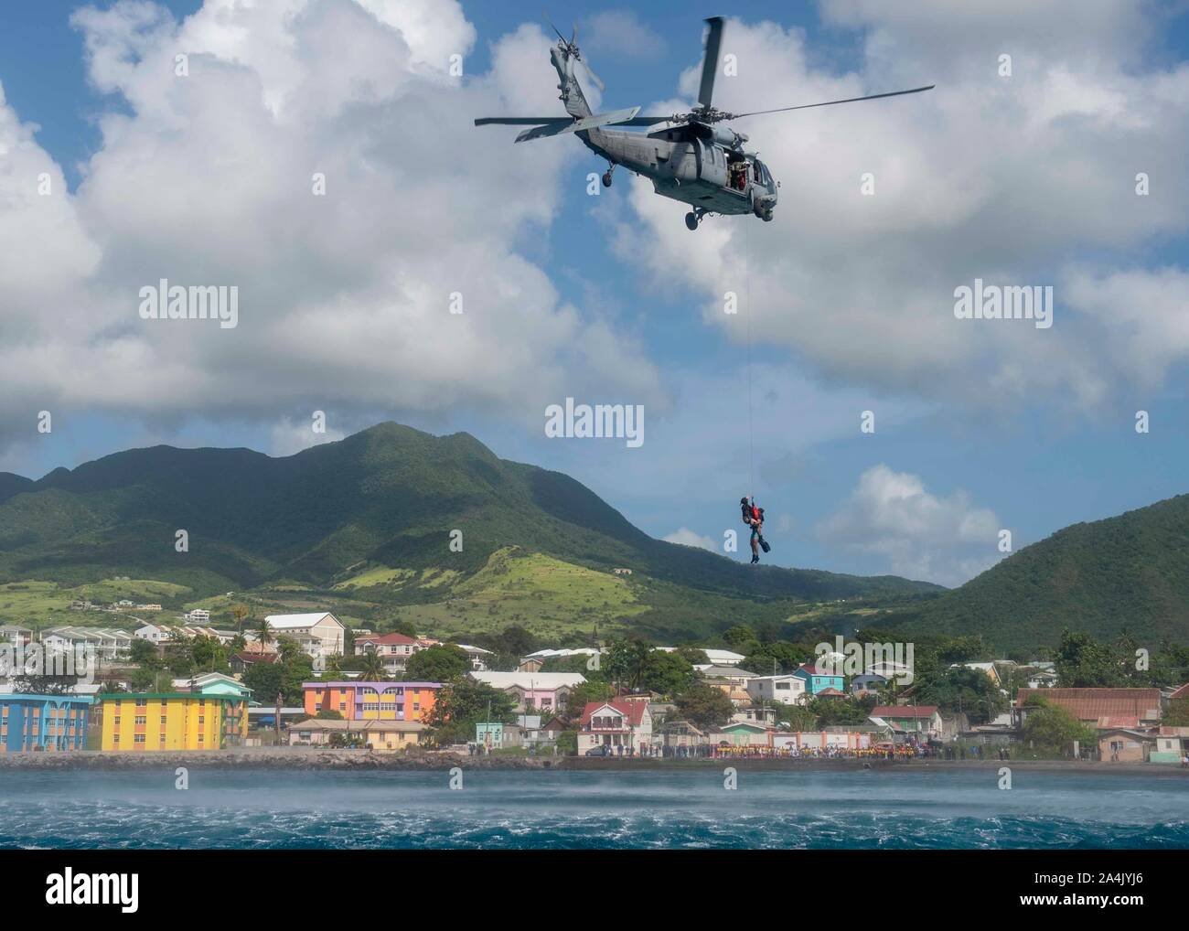 U.S. Navy Naval Aircrewman (Hubschrauber) 2. Klasse Benjamin Lazarus, Hebezeuge Naval Aircrewman (Hubschrauber) 2. Klasse Bruno Ferreria, sowohl für die "Dragon Wale" von Hubschrauber Meer Combat Squadron 28, angeschlossen an das Krankenhaus ship USNS Comfort (T-AH 20), in einem MH-60S Seahawk während einer Suche und Rettung Demonstration vor der Küste von Basseterre, St. Kitts und Nevis, Okt. 11, 2019. Komfort ist das Arbeiten mit Gesundheit und Regierung Partner in Mittelamerika, Südamerika und die Karibik zu kümmern, auf dem Schiff und an Land-basierte medizinische Websites, wodurch der Druck auf die nationalen mich zu entlasten Stockfoto