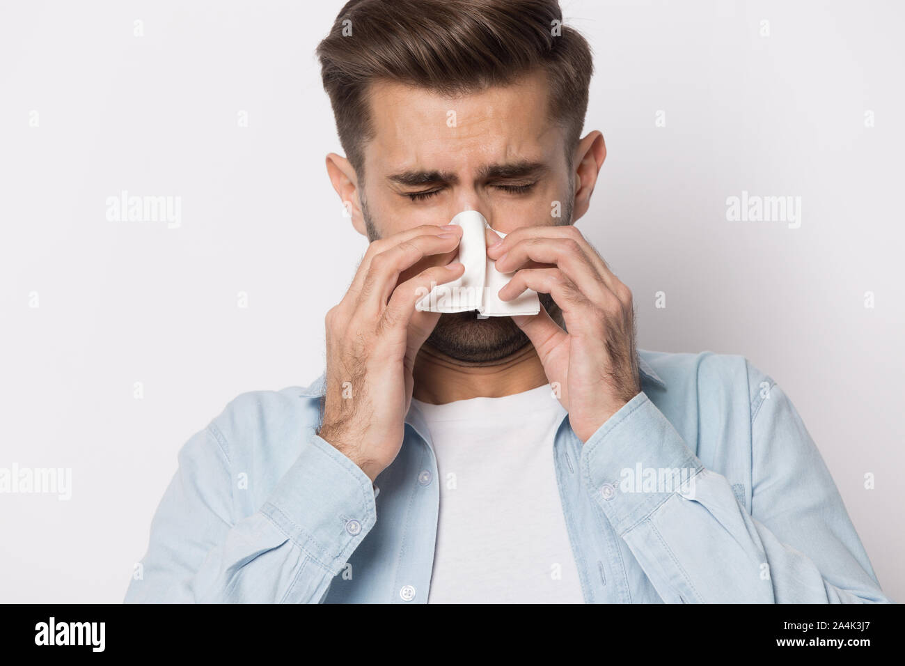 Ungesunde kaukasischen Mann blasen Nase leiden an Grippe Stockfoto