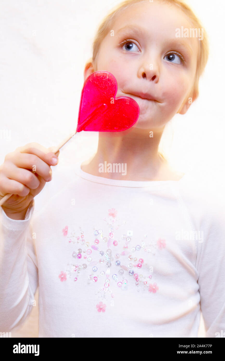 Mädchen schmeckt ein pink Lollypop. Stockfoto