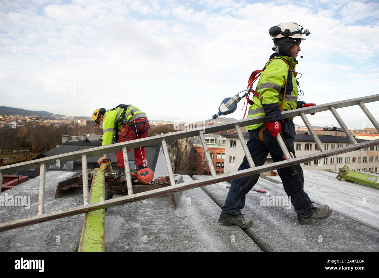 Arbeiter mit Leiter auf dem Dach in Norwegen Stockfoto