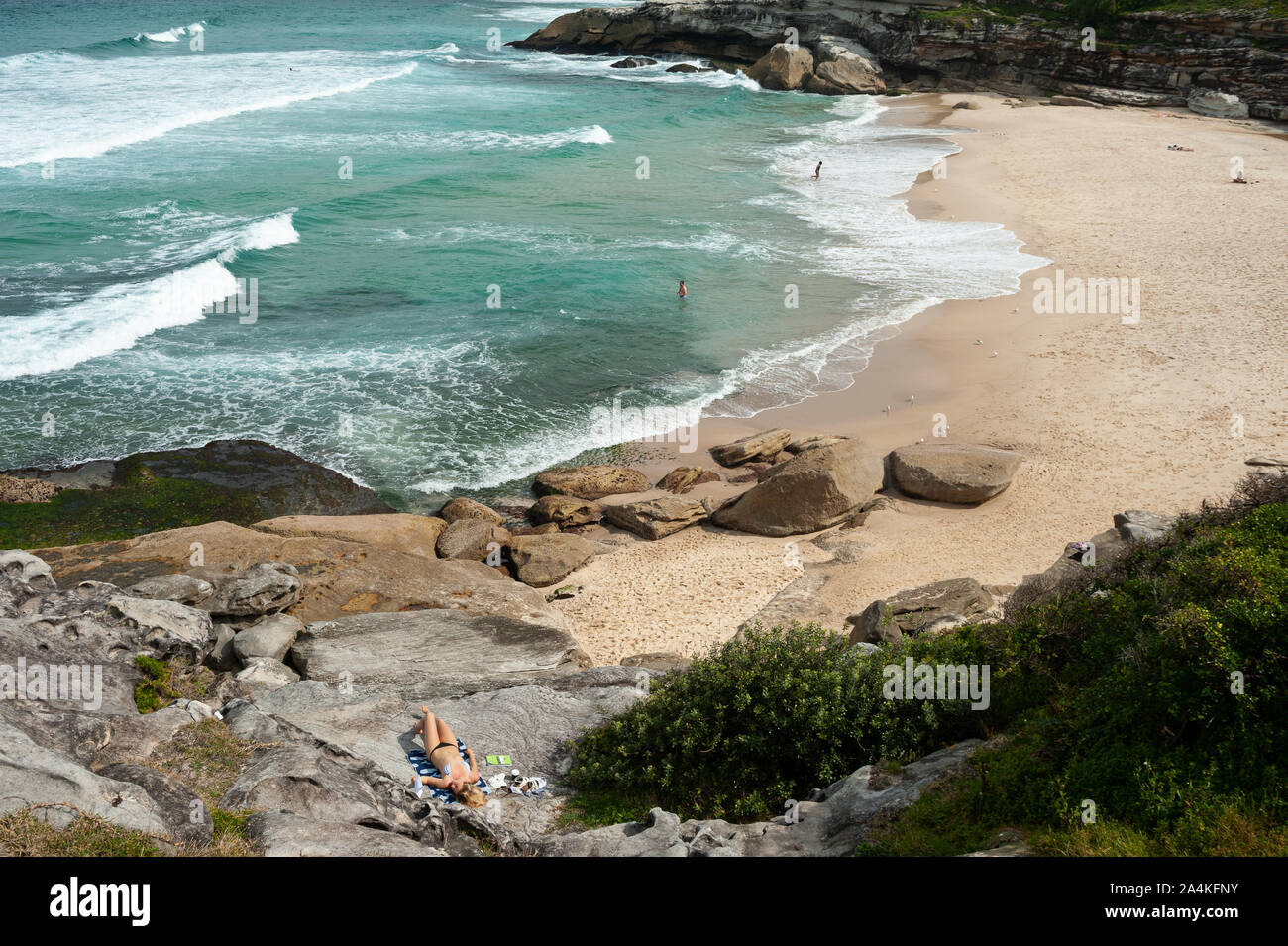 27.09.2019, Sydney, New South Wales, Australien - eine Frau sunbathes auf den Felsen in der Nähe: Tamarama Beach. Stockfoto