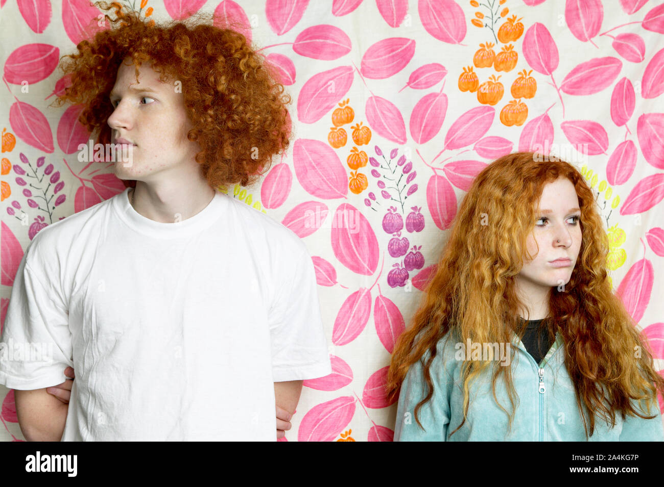 Junge und Mädchen mit lockigem Lange rote Haare, die in entgegengesetzte Richtungen. Stockfoto