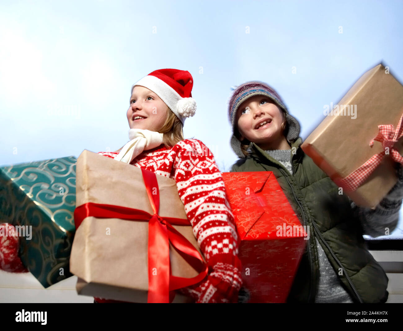 Mädchen mit Weihnachtsmütze und gestrickte wollen hat die Weihnachtsgeschenke Stockfoto