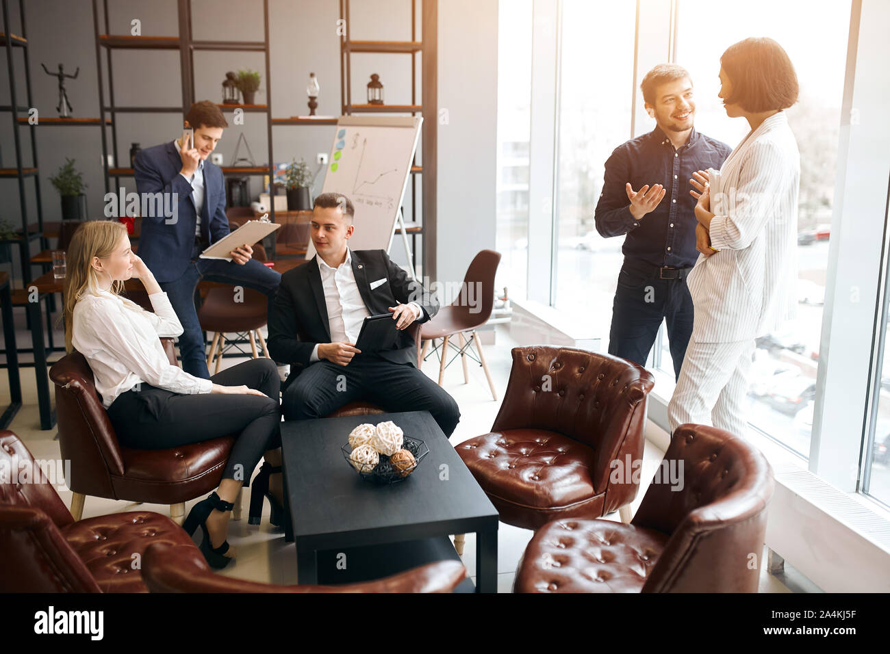 Junge entspannt positiven Menschen in formalen stilvolle Kleidung in eine Pause am Arbeitsplatz, geschäftige Atmosphäre im Büro Zimmer Stockfoto