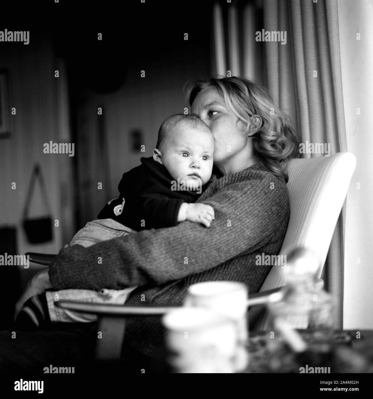 Junge Mutter in einem Stuhl mit Baby Stockfoto