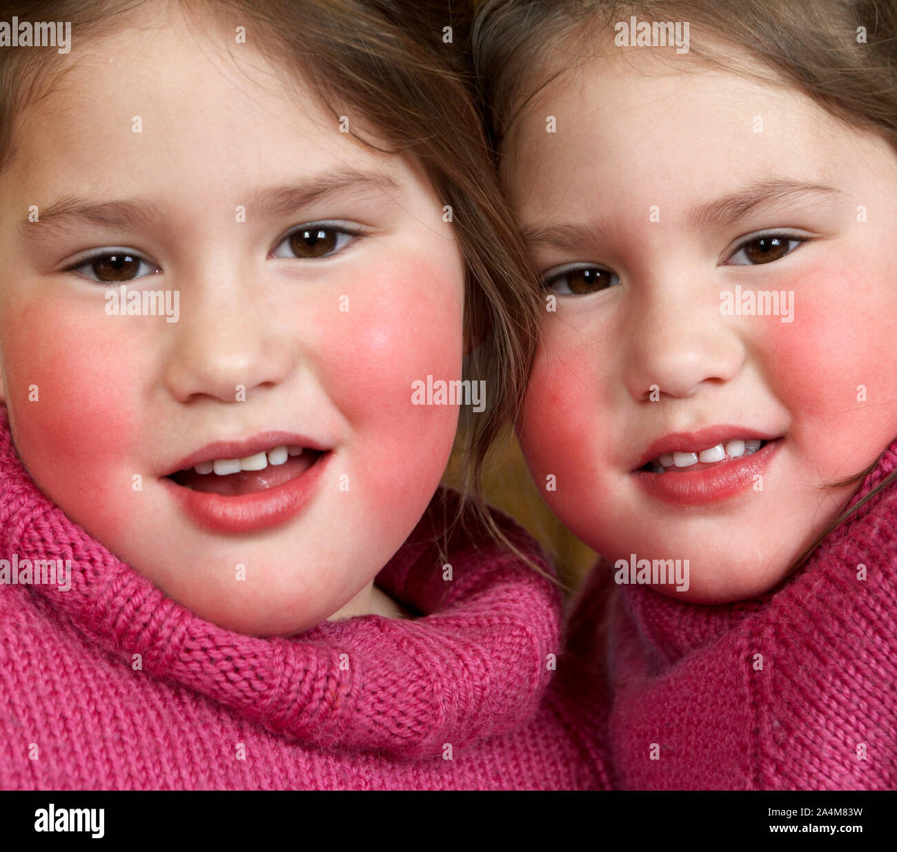 Zwei Mädchen mit braunen Augen - in rosa Pullover. Stockfoto