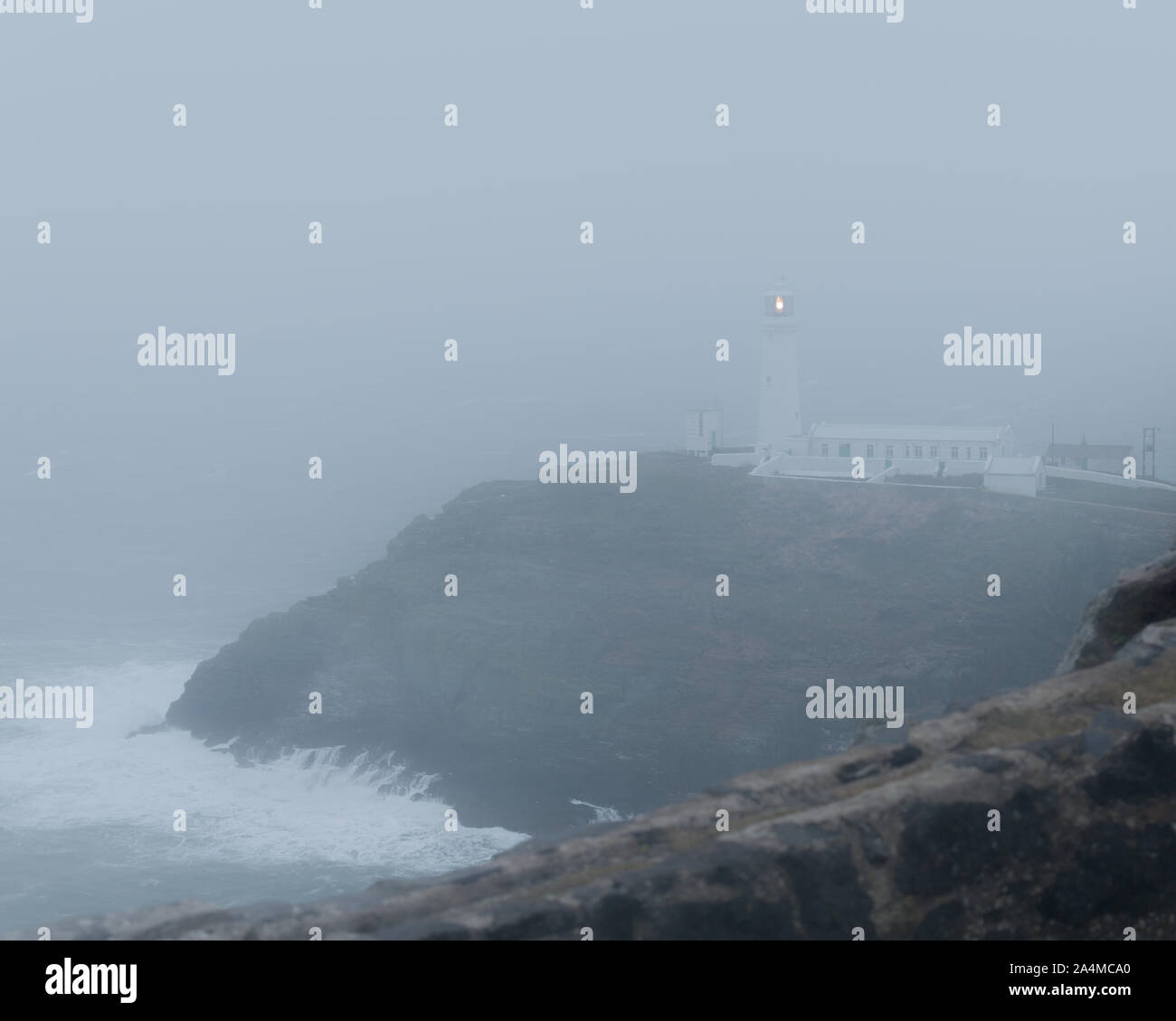 South Stack, heilige Insel/Wales - 14. Februar 2018 - Regen und Nebel ausblenden South Stack Leuchtturm im Sturm mit Wellen Stockfoto
