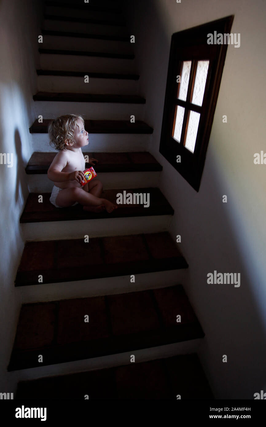 Kind im Treppenhaus Blick aus einem Fenster Stockfoto