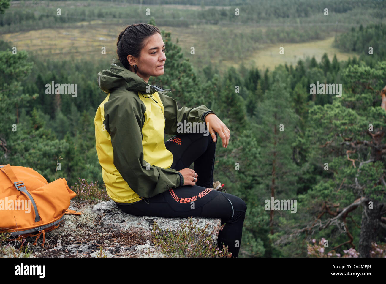 Frau sitzt auf Felsen Stockfoto