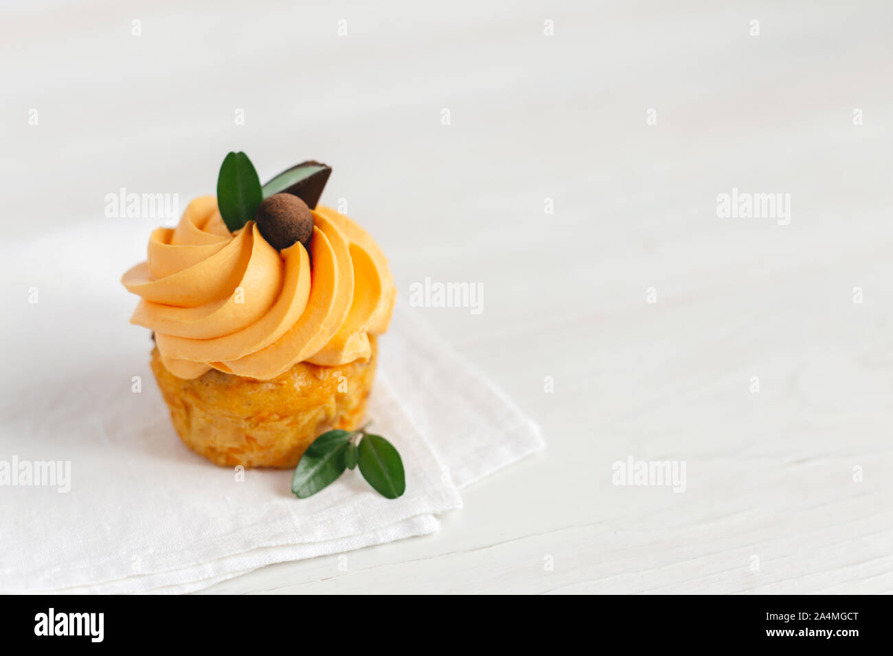 Lecker Kürbis Cupcake mit orange Creme und Dekoration auf weiße Holztisch. Für Text platzieren. Stockfoto