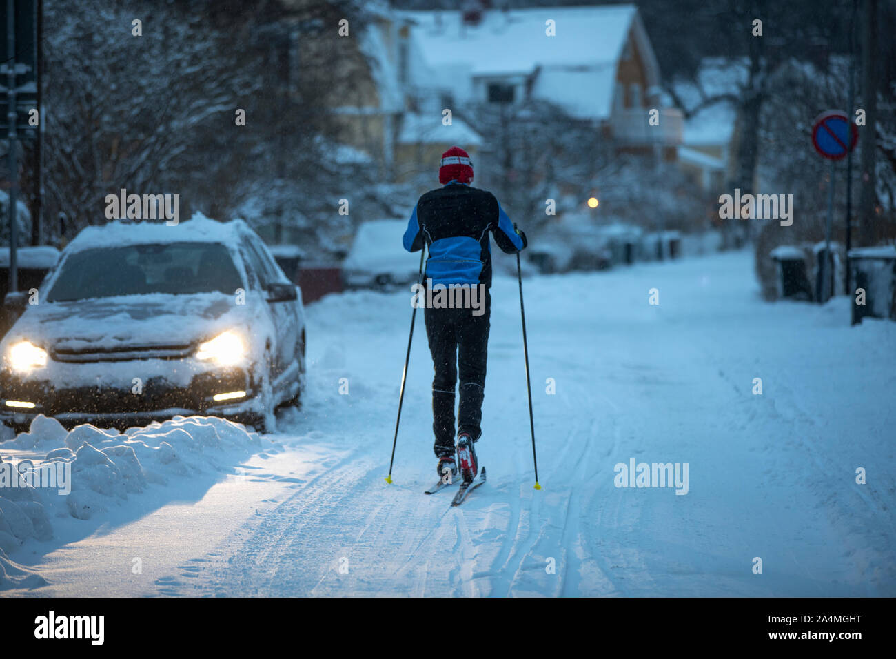 Mann Langlauf im Dorf in der Dämmerung Stockfoto