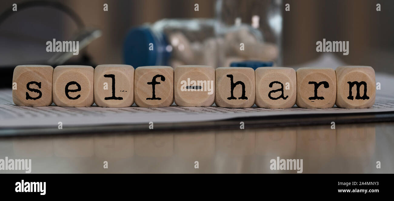 Wort selbst aus Holz Würfel. Pillen, Dokumente und ein Stift im Hintergrund. Nahaufnahme Stockfoto