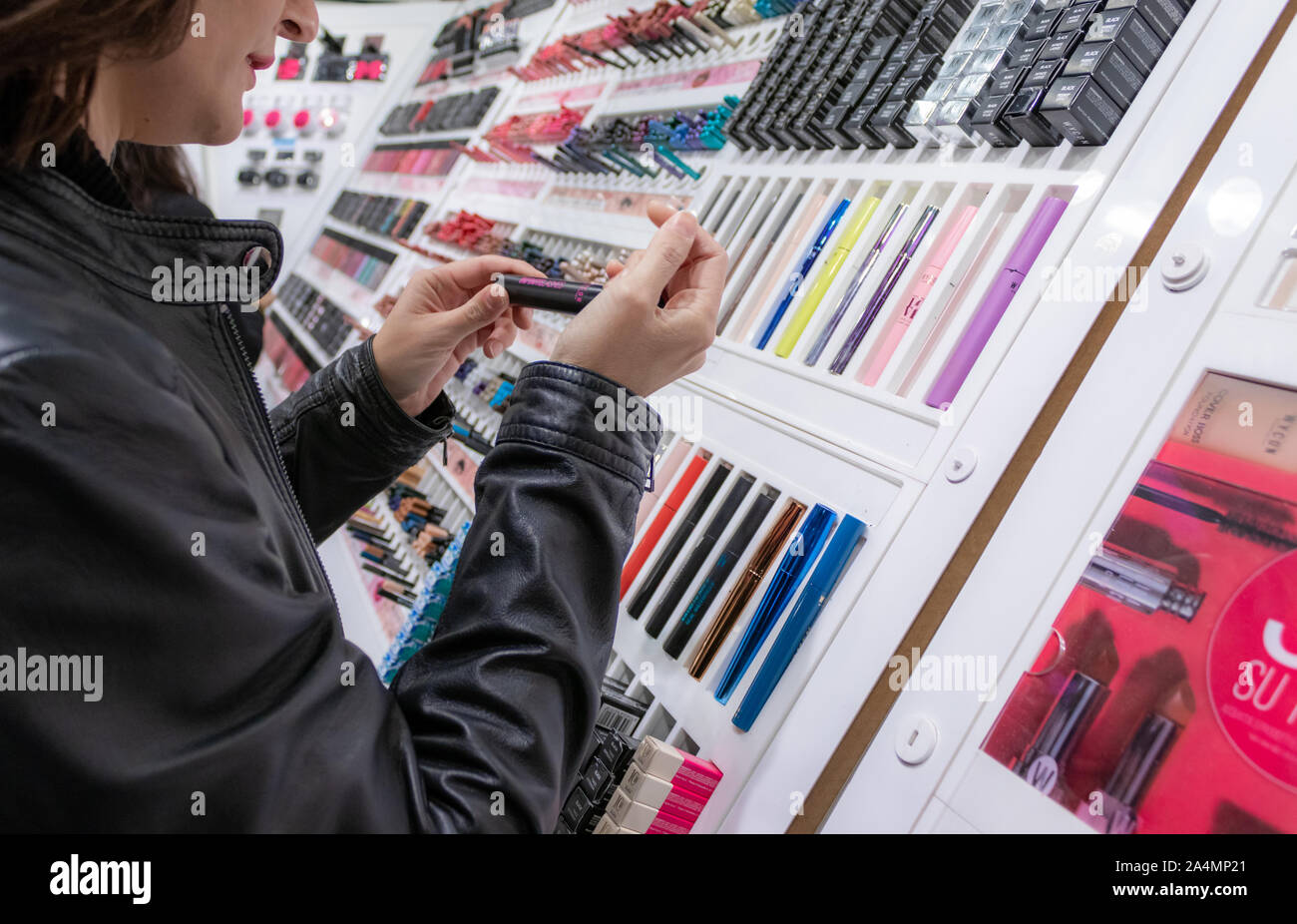 Parma, Italien - 13. Oktober 2019: Junge Mädchen mit leder jacke Prüfung Elemente in einer Make up Store Stockfoto