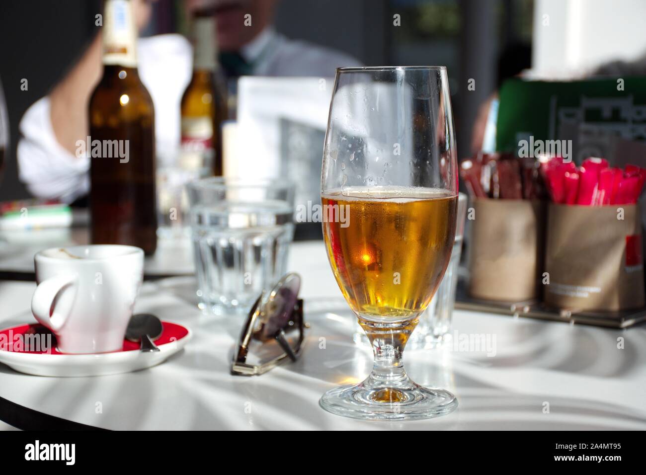 Tasse Kaffee und ein Glas Bier auf den Tisch im Restaurant bei Sonneneinstrahlung Stockfoto