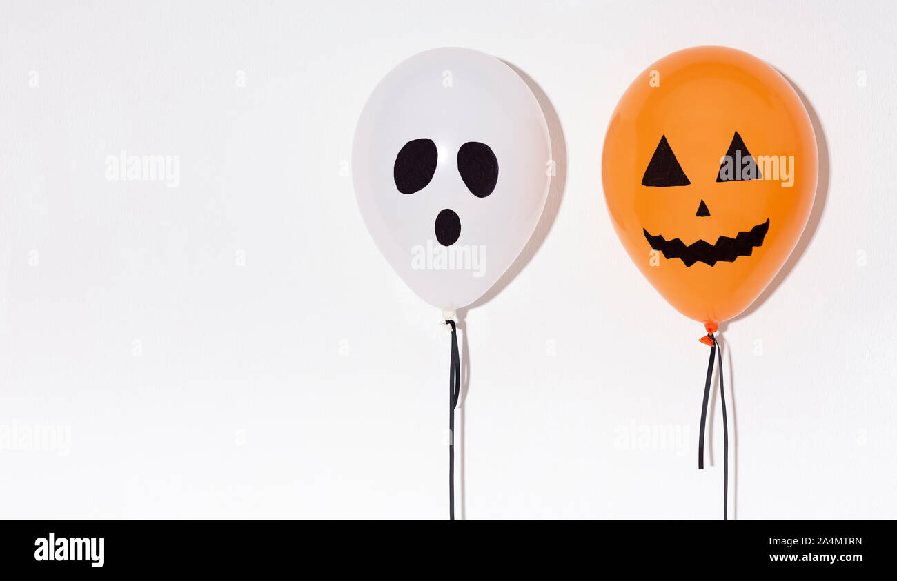 Zwei Halloween Luftballons mit lustige Gesichter isoliert auf weißem Stockfoto
