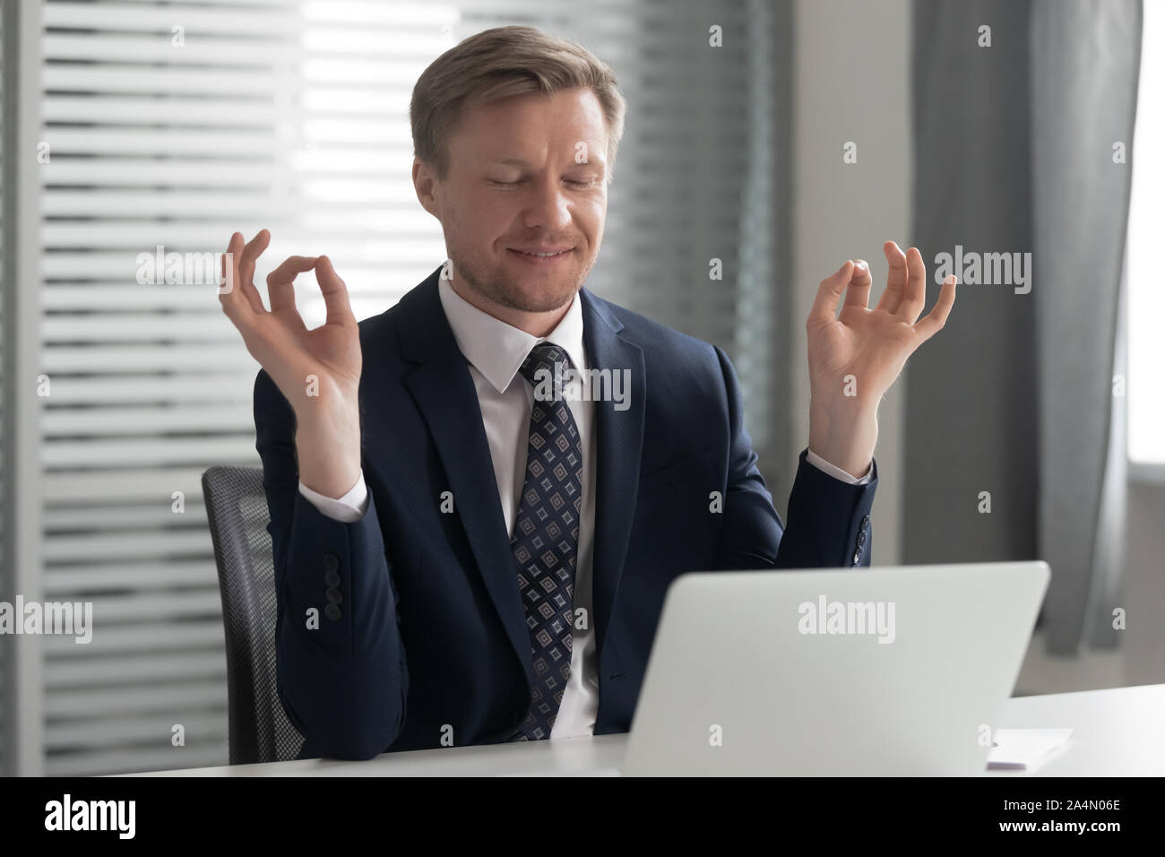 Zufrieden Geschäftsmann entspannen, meditieren, Yoga pose am Arbeitsplatz Stockfoto