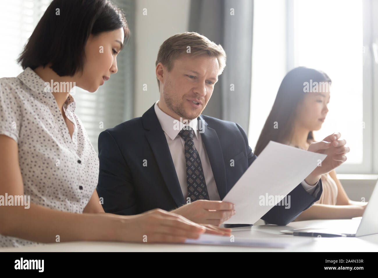 Asiatische Geschäftsfrau diskutieren rechtliche Dokumente mit kaukasischen Geschäftsmann Stockfoto