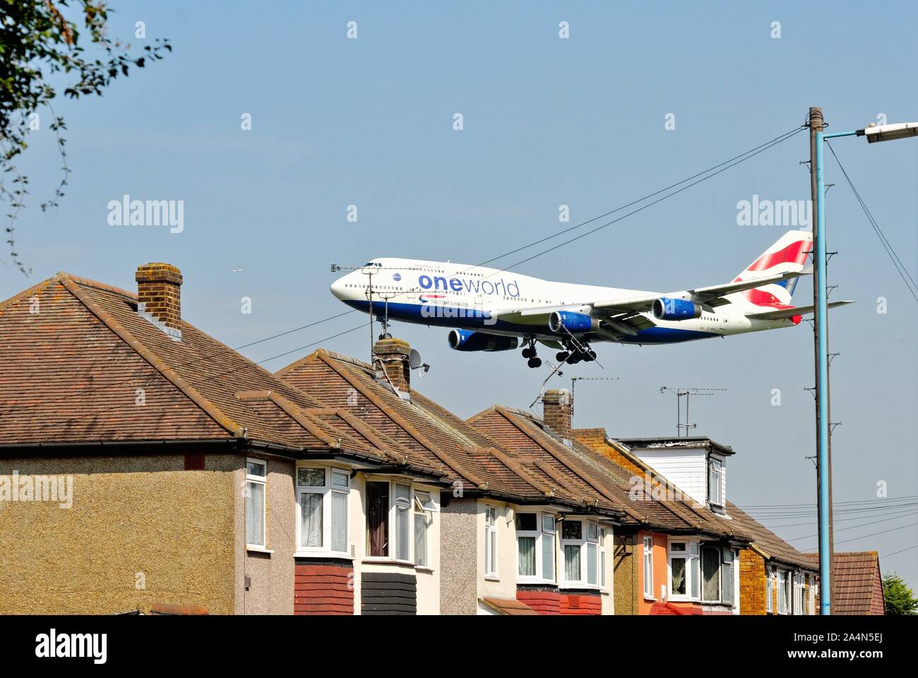 Einen British Airways Jumbo Jet über die Dächer am Hatton Cross fliegen über am Heathrow Airport London England Großbritannien zu Land Stockfoto