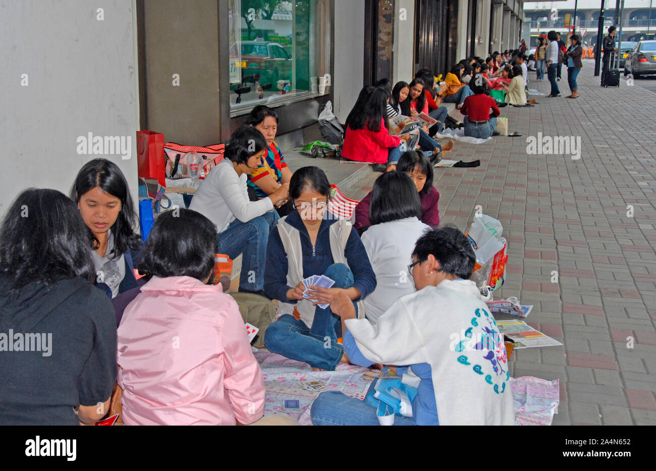 Eingewanderte Arbeiter Frauen spielen Karte in Straße, Hong Kong Island, China Stockfoto
