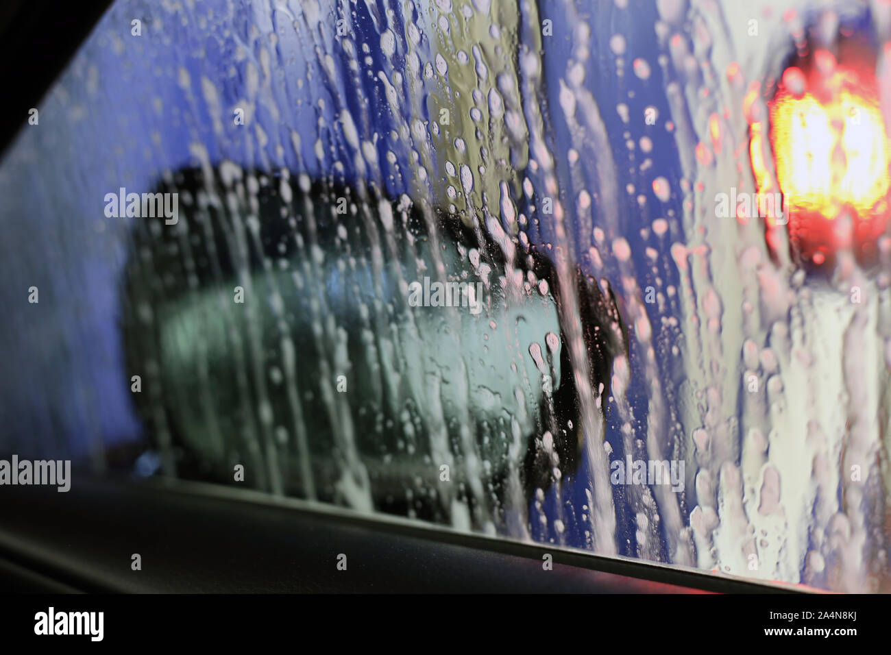 Innerhalb einer Autowaschanlage, die Auto gereinigt. Auf diesem Foto sehen Sie die Fenster mit einigen Blasen und Wasser bedeckt. Stockfoto