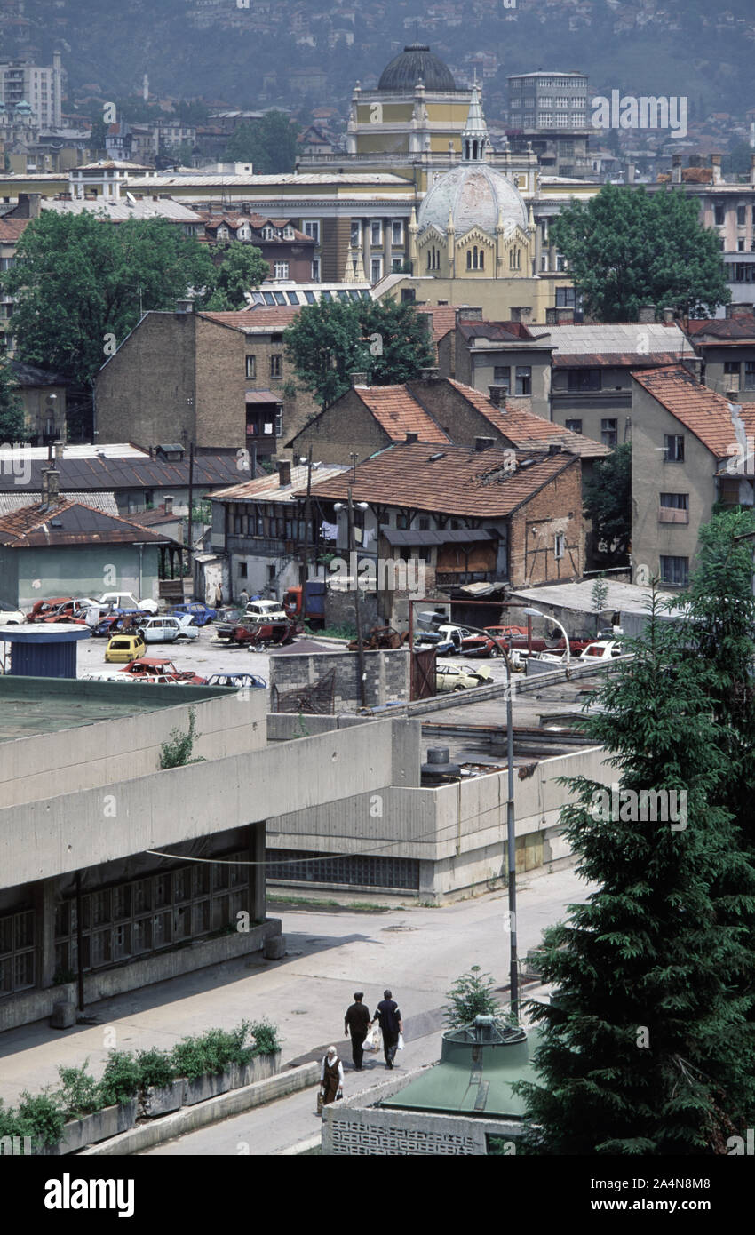 5. Juni 1993 während der Belagerung von Sarajevo: Die Ansicht nord-östlich von Stolačka Straße in Richtung des grünen Kuppel der Akademie der Bildenden Künste (ehemals Evangelische Kirche. Jenseits der Kirche ist die Juristische Fakultät der Gebäude der Universität Sarajevo und der quadratische Turm der Vakuf Wolkenkratzer (lokal wie die JAT Wolkenkratzer bekannt). Stockfoto