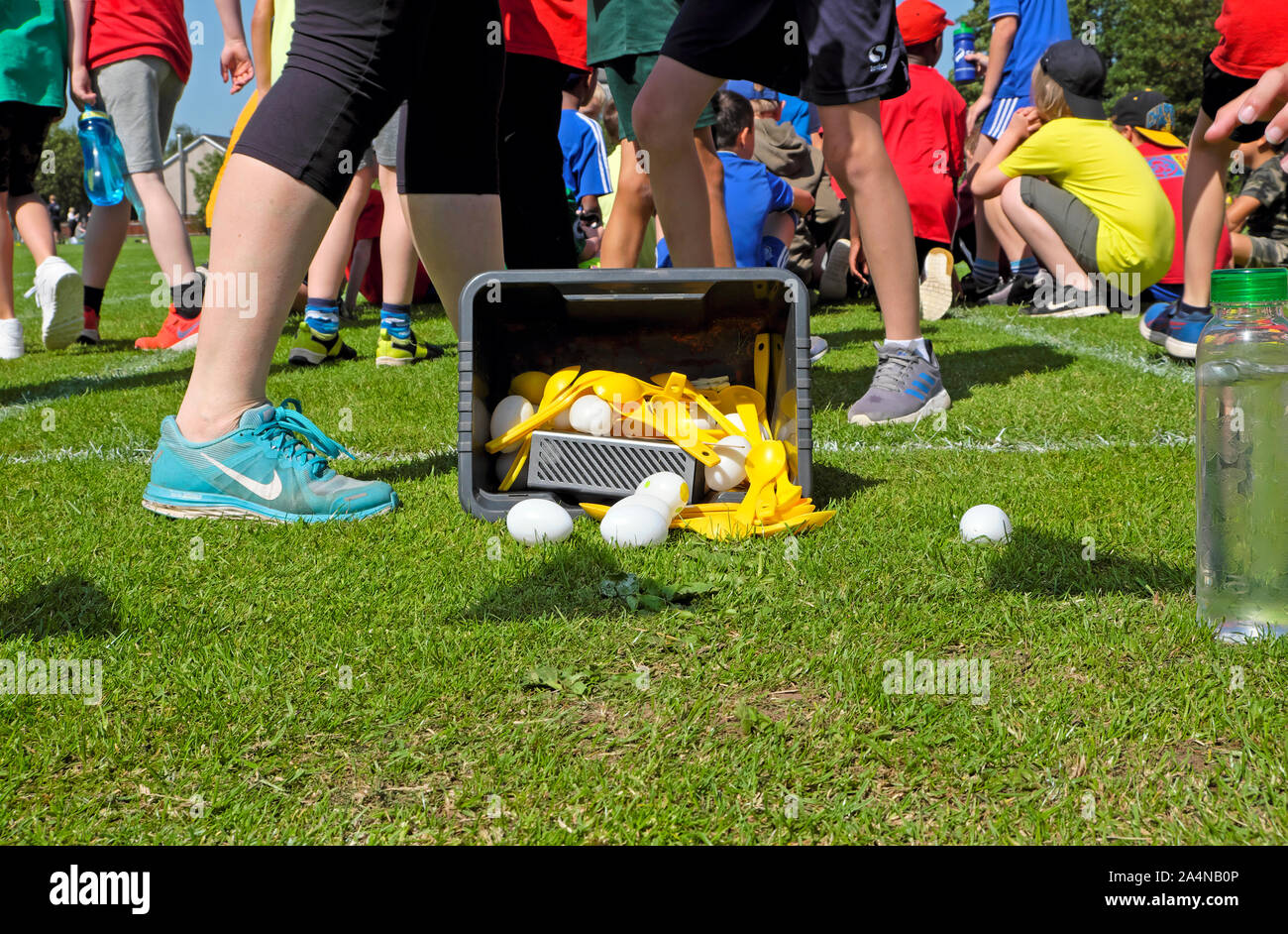 Grundschule Kinder draußen spielen Spiele Ei und Löffel Rennen am Tag des Sports in Großbritannien, Großbritannien Stockfoto