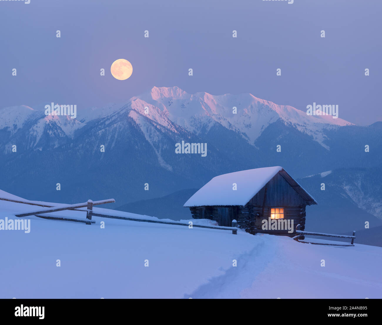 Weihnachten Landschaft mit einem verschneiten Haus in den Bergen. Märchen Nacht mit Vollmond. Winterlandschaft mit Spuren im Schnee. Stockfoto