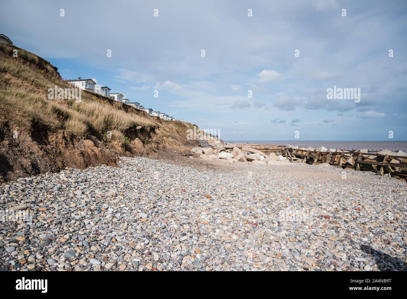 Blick entlang der Felswand von Hornsea Strand zeigen Beispiele für Küstenschutz und stürzte die Klippen von geschiebelehm. Stockfoto