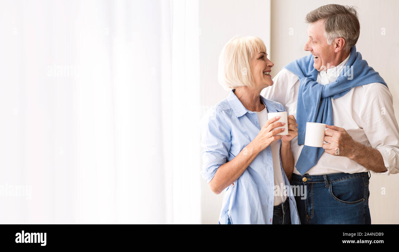 Gerne älteres Ehepaar miteinander reden in der Nähe der Fenster und Tee trinken. Stockfoto