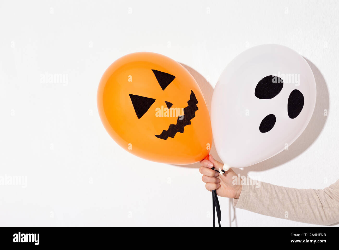 Bündel von Halloween Luftballons mit unheimlichen Gesichter in der Frau die Hand Stockfoto