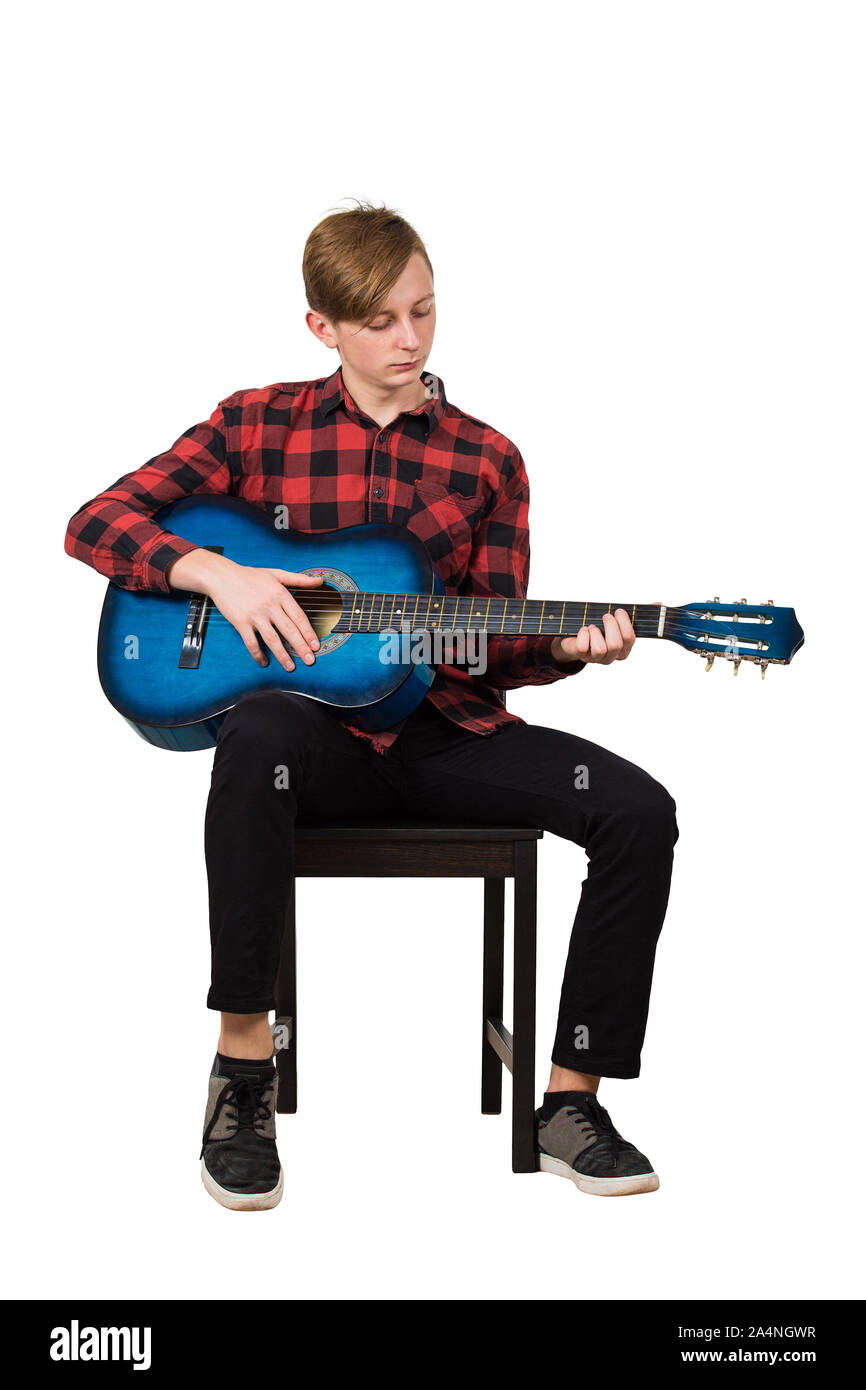 In voller Länge Porträt der talentierte junge Teenager spielen auf der akustischen Gitarre auf einem Stuhl auf weißem Hintergrund sitzt. Tolle Musik lehren fo Stockfoto