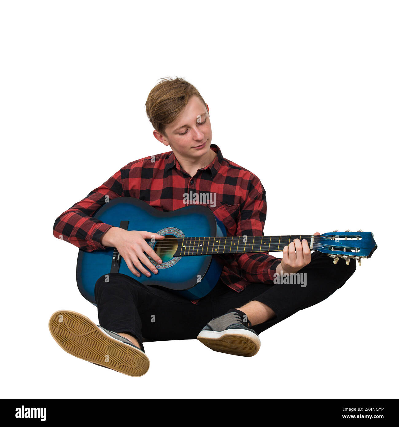 In voller Länge Porträt der talentierte junge Teenager spielen auf der akustischen Gitarre auf dem Boden sitzt isoliert auf weißem Hintergrund. Tolle Musik Unterricht f Stockfoto