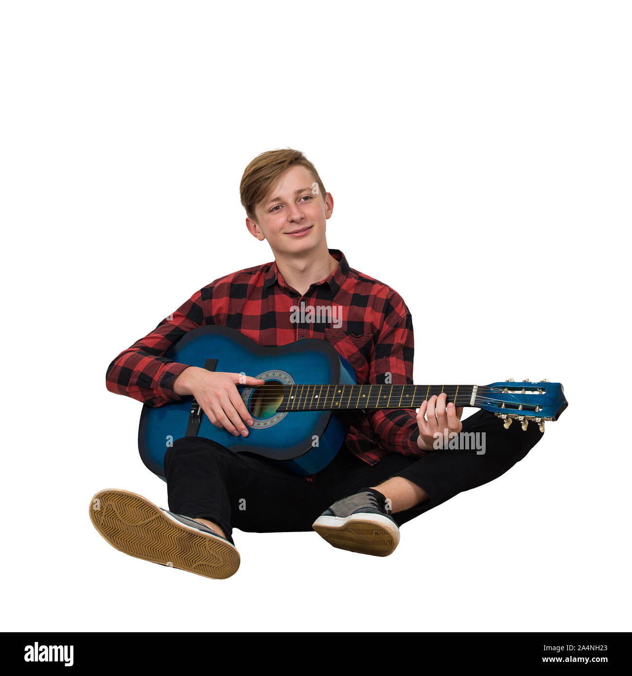In voller Länge Porträt der talentierte junge Teenager spielen auf der akustischen Gitarre auf dem Boden sitzt isoliert auf weißem Hintergrund. Tolle Musik Unterricht Stockfoto