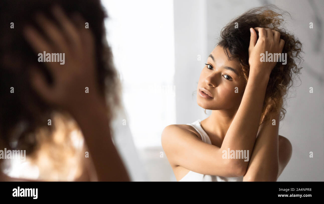 Afro Frau berühren, das Haar im Spiegel im Bad, Panorama Stockfoto
