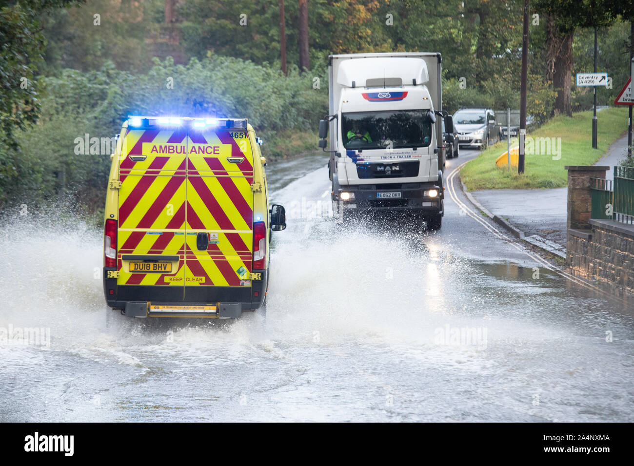 Ein Krankenwagen machen es seinen Weg durch die überschwemmten Ford in der Castle Street Kenilworth nach neuen schweren Regen und Sturm Stockfoto