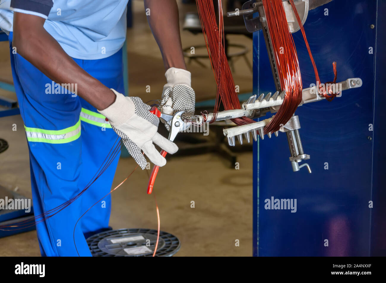 Afrikanische Arbeiter Reparaturen durchführen bei einem Elektromotor, zurückspulen Stockfoto