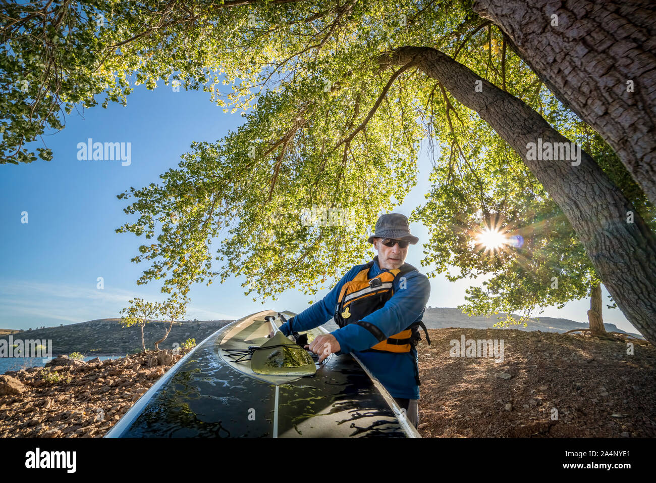 Ältere Männchen ist mit einem Stand up paddleboard am Ufer des Bergsees, Action Kamera POV Stockfoto