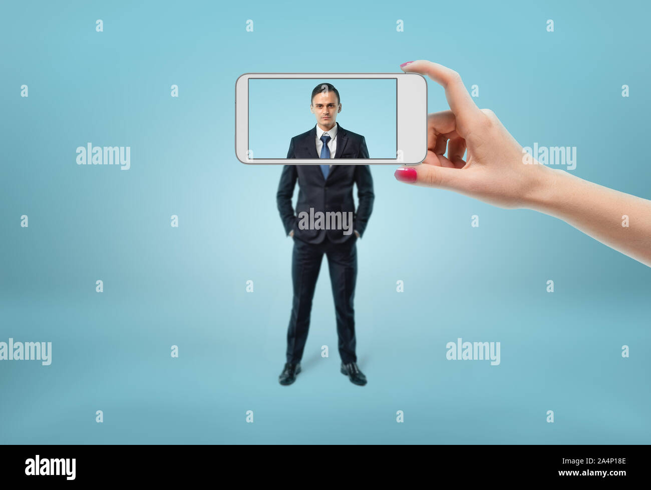 Der Geschäftsmann Gesicht im Fokus sehen durch den Rahmen der Telefon. Stockfoto