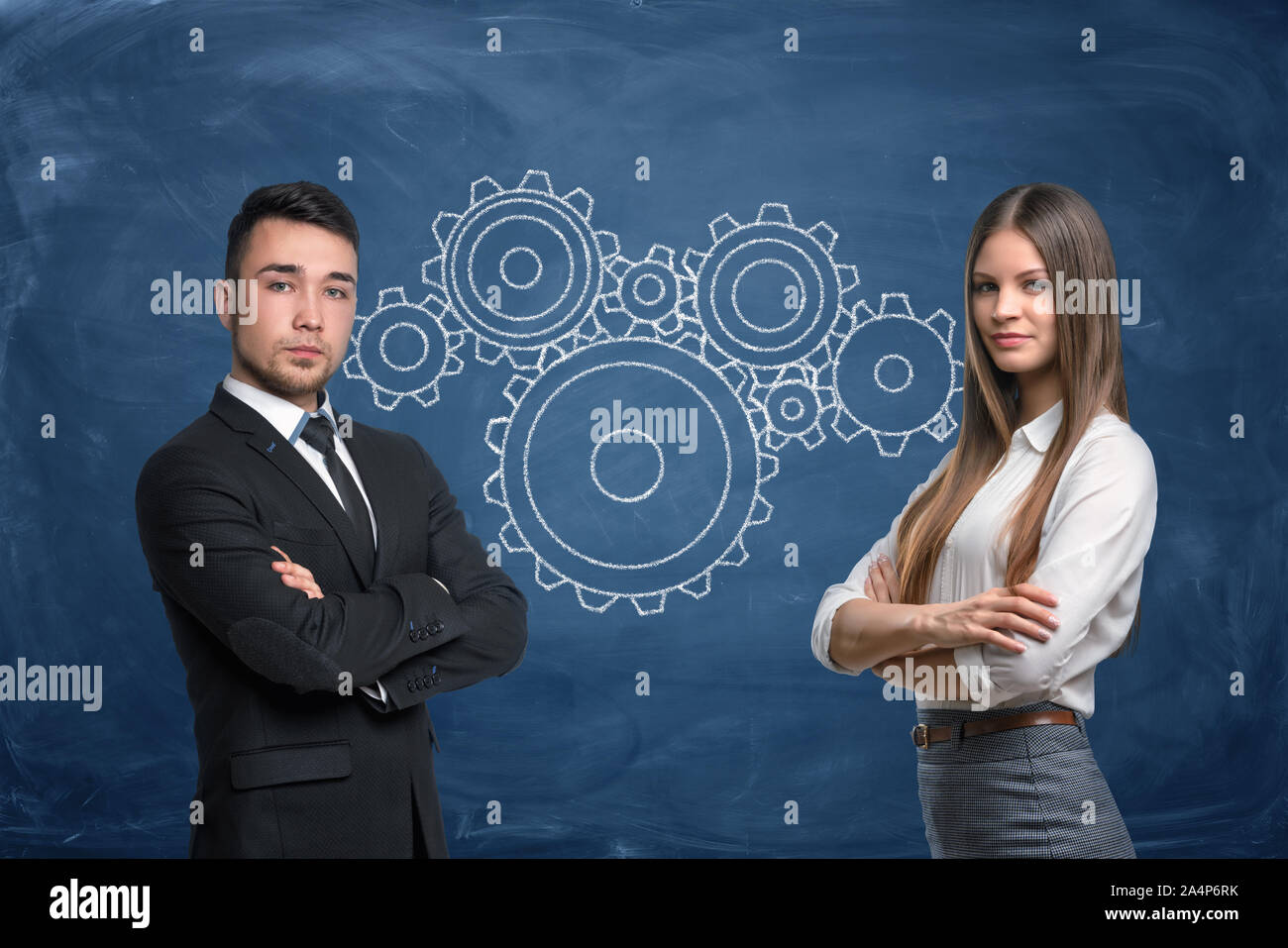 Kaufmann und Kauffrau mit Zahnrädern arbeiten im Team auf blauem Hintergrund Stockfoto